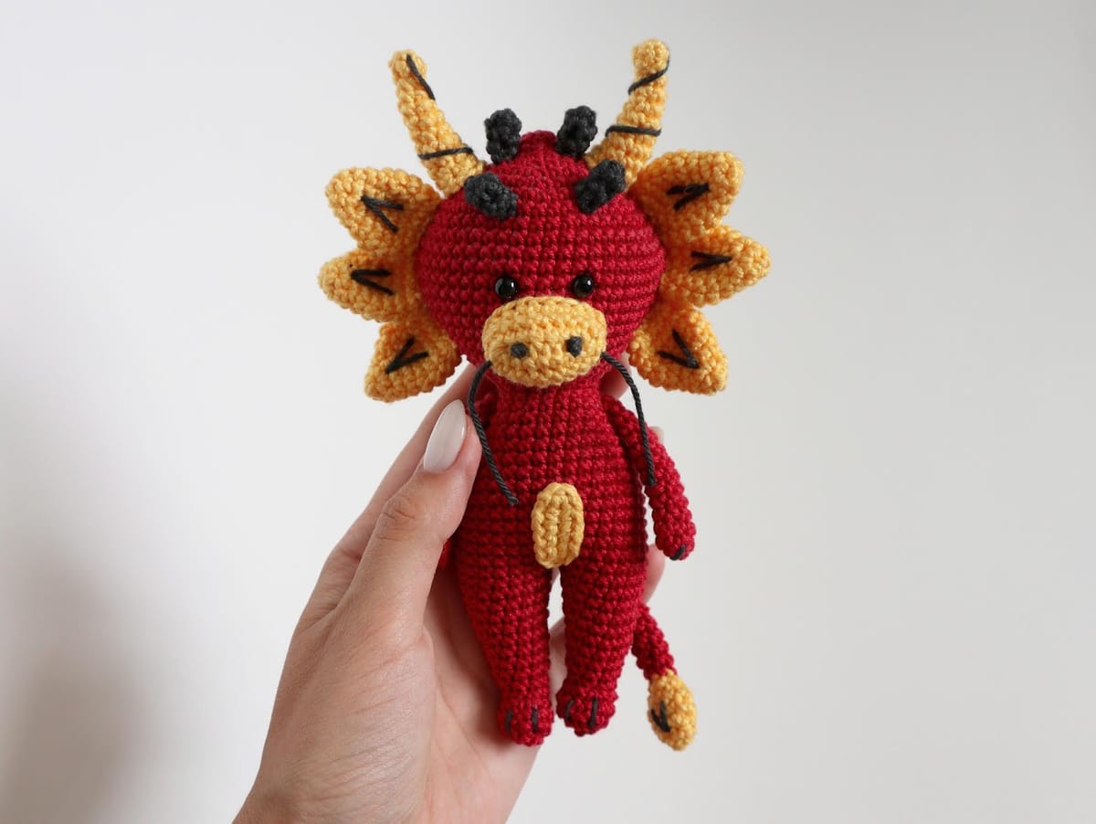 Crocheted little red dragon with golden horns